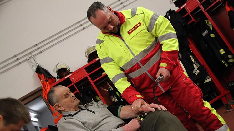 Torsten Hereth demonstriert einen Einsatz der First Responder Gruppe der Zeitlofser Feuerwehr. Der 81-jährige Michael Schneider machte gerne bei der Übung mit, denn er hat schon mehrfach von der schnellen Hilfe profitiert. Foto: Ulrike Müller