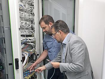 Kleines Kabel mit großer Wirkung. 1. Bürgermeister Karsten Fischkal (rechts) und IT-Experte Gerhard Lang (links) freuen sich über die neue, leistungsstarke Internetanbindung