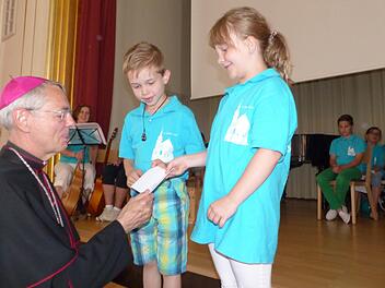 Die Thurndorfer Kinder- und Jugendchormitglieder Johannes und Lea freuen sich, dass der Erzbischof ihnen den Scheck anvertraut. Fotos: Bärbel Meister