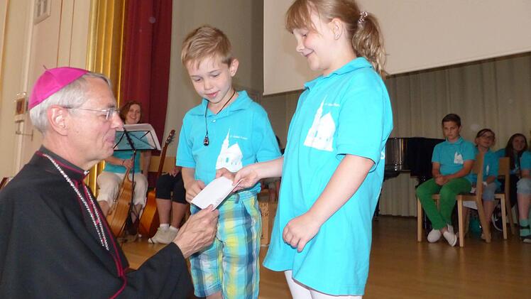 Die Thurndorfer Kinder- und Jugendchormitglieder Johannes und Lea freuen sich, dass der Erzbischof ihnen den Scheck anvertraut. Fotos: Bärbel Meister