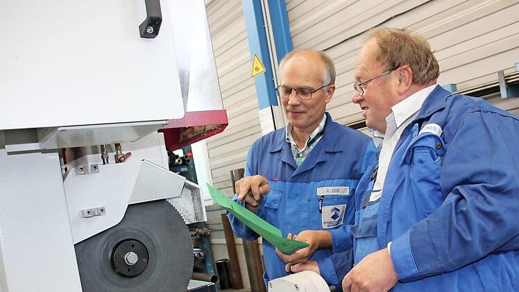 Der Kulmbacher Gerhard Hacker (rechts) ist nach 33 Jahren bei der Maschinenfabrik Fischer in den Ruhestand gegangen. Anhand einer Laufkarte, die Meister Andreas Zeis hält, schneidet er noch einmal ein Rechteckrohr aus Stahl an einer Säge zurecht.  Foto: Stephan Stöckel