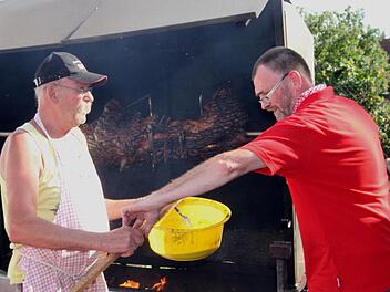 Gleich ist die "Sau" so weit. Organisationsleiter Alois Böhnlein (rechts) und Raimund Geheb überzeugen sich noch einmal vom richtigen Grillzustand. Foto: Günther Geiling