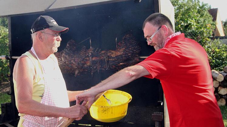 Gleich ist die "Sau" so weit. Organisationsleiter Alois Böhnlein (rechts) und Raimund Geheb überzeugen sich noch einmal vom richtigen Grillzustand. Foto: Günther Geiling