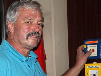 Hofft, dass er diesen Knopf niemals drücken muss: Hausmeister Bernd Ditzel weiß um die Mängel beim Brandschutz. Foto: Ulrike Müller