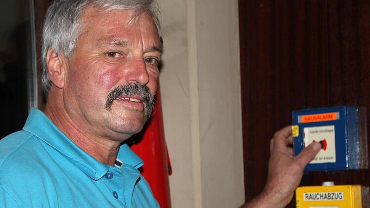 Hofft, dass er diesen Knopf niemals drücken muss: Hausmeister Bernd Ditzel weiß um die Mängel beim Brandschutz. Foto: Ulrike Müller