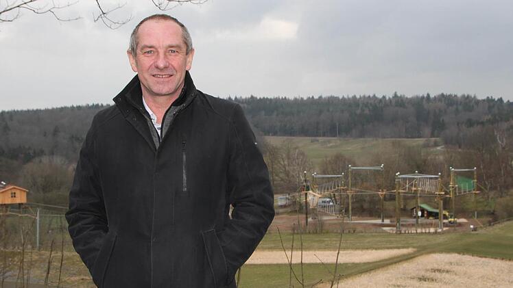 Klaus Hofmann ist seit dem Jahr 2002 Rektor von Haus Volkersberg. Er freut sich über den neuen Hochseilgarten (im Hintergrund). Foto: Ulrike Müller