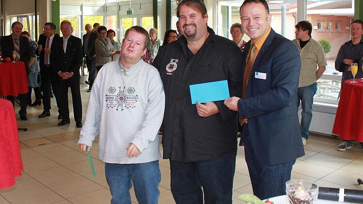 Werkstattleiter Detlef Troll (r.) gratuliert den Namensgebern des Cafés. Foto: Tina Meier