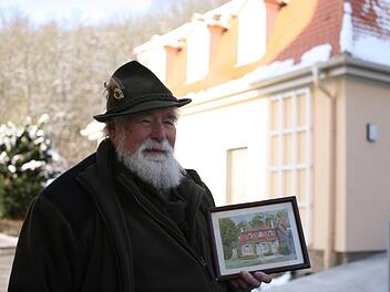 Siegfried Ritter mit einem gemalten Bild, das einen Teil seines Elternhauses im Jahr 1941 zeigt. Der Geb&auml;udekomplex ist verschwunden, wurde nur teilweise wieder aufgebaut. Der 83-J&auml;hrige hingegen hat ihn &uuml;berdauert, verbrachte fast sein ganzes Leben im Staatsbad. Foto: Steffen Standke