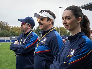 Mit Coach Beard (Brendan Hunt) und der schroffen Alice Chilton (Tanya Reynolds) hat Ted Lasso (Jason Sudeikis, Mitte) zwei hervorragende Co-Trainer an seiner Seite.