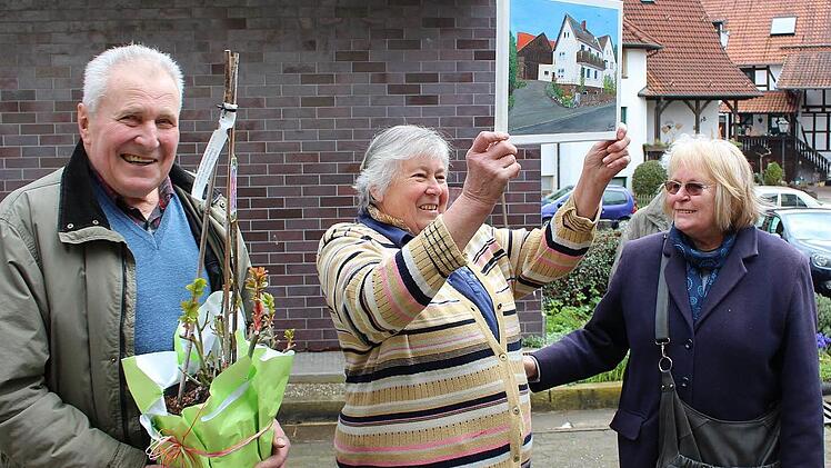 Ewald und Edith Mönch (Mitte) waren am Freitag letztmals Gastgeber für die Gartenfreunde. Hobbykünstlerin Maria Schmidt dankte dem Ehepaar dafür mit einem selbstgemalten Bild des Mönch-Hofes. Foto: Ulrike Nauer