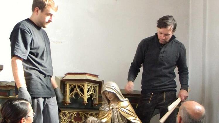 Pfarrer Steffel beobachtet den Abbau der beiden Seitenaltäre der Pfarrkirche Hallerndorf. Foto: Sonja Lengenfelder