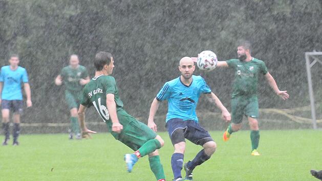 Der Machtilsh&auml;user Artur Sibert (Mitte) hat den Ball trotz Starkregens gegen den Garitzer Lucas Clement fest im Blick. Foto: ssp