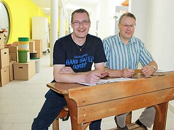 Planer Jochen Gleich (links) und Schulleiter Ulrich Weiß haben auf einer alten Schulbank im neuen Aktionsflur Platz genommen.Fotos: Corinna Igler