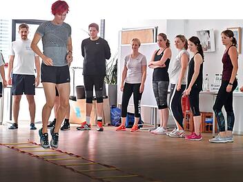 Hüpfen, springen, dehnen und mehr: Die mehrfache Biathlon-Olympiasiegerin hat die Angestellten der Mediengruppe Oberfranken am Dienstag von den Schreibtischen zum Sport bewegt. Foto: Ronald Rinklef