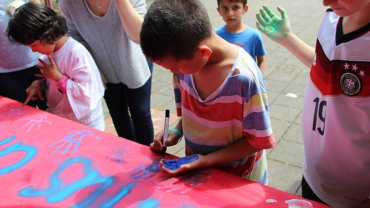 Nach dem Spiel zeigten alle Jugendlichen mit ihren Handabdrücken auf einem roten Banner, dass sie dem Rassismus in Hammelburg keine Chance bieten. Foto: Wiesner