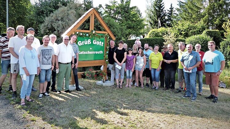 Übergabe einer Begrüßungstafel in Katschenreuth mit Feuerwehrvorsitzendem Erwin Lauterbach (Fünfter von rechts) sowie rechts an der Ortstafel OB Henry Schramm und (weiter nach links) den CSU-Stadträten Thorsten Grampp, Lothar Seyfferth und Horst Zahr Foto: Werner Reißaus