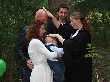 Vikarin Johanna Thein segnet Mama Simone, Patenonkel Andy, den kleinen Elljot und Papa Frank bei der Taufe im Wald. Foto: Henning Schuster