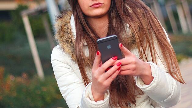 Junge Frau mit Smartphone/Handy in der Hand