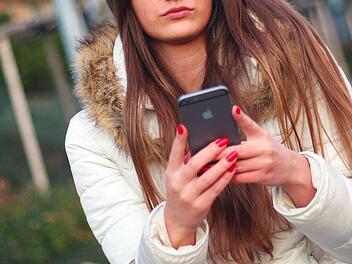 Junge Frau mit Smartphone/Handy in der Hand