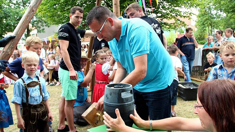 Bürgermeister Karsten Fischkal sticht das Apfelschorle-Fass an.