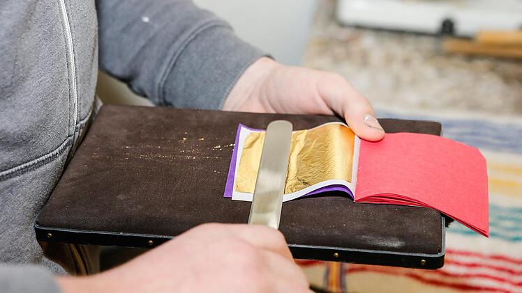 Vorsichtig schneidet der Azubi mit einem speziellen Messer ein Bl&auml;ttchen im Block.