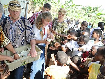Die Gäste aus Hannberg verteilen nach der Einweihung der Krankenstation in Busagula als Gastgeschenk 2000 Joghurt-Tüten der Molkerei von Caritas Maddo an alle Besucher. Foto: Stefan Reinmann