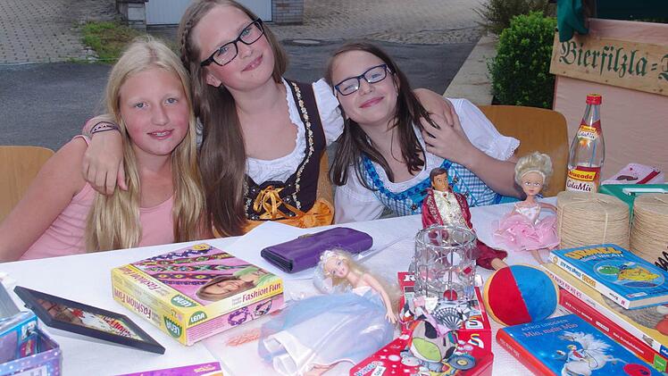 Diese drei jungen Damen boten ihre Spielsachen bei einem Flohmarkt an.