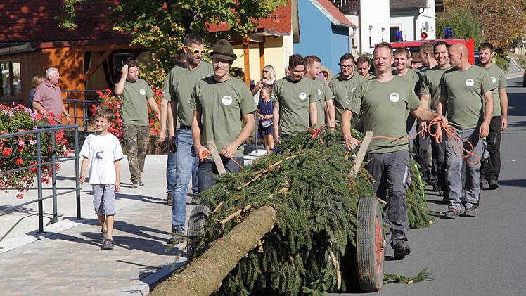 Stolz ziehen die Kirchweihburschen mit dem 23 Meter langen Baum durch den Ort.  Foto: Matthias Erlwein