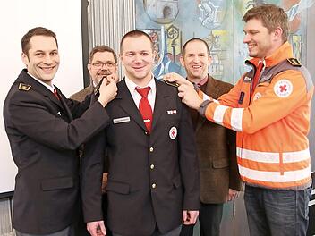 Daniel Völler (links) und der Bezirkskreisbereitschaftsleiter Johannes Stegmann brachten die Schulterklappen an der Uniform von Claus Weigand an. Mit im Bild Landrat Rainer Mattern und Siegfried Wölki (hinten, von links) Foto: Michael Stelzner
