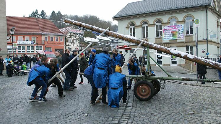 Mit vereinten Kräften wurde am Samstag am Eltmanner Marktplatz der Narrenbaum errichtet, der mit seinen Schildern auf die verschiedenen Faschingsveranstaltungen in der Wallburgstadt hinweist.