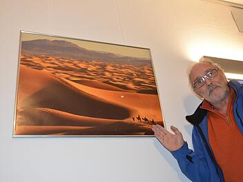 Peter Rex vor einem Foto der marokkanischen Wüste. 33 Aufnahmen seiner Reisen werden ausgestellt.  Foto: Bernhard Panzer