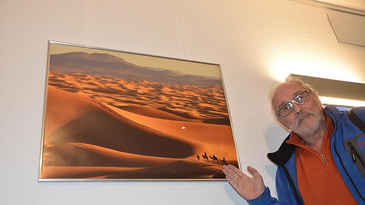 Peter Rex vor einem Foto der marokkanischen Wüste. 33 Aufnahmen seiner Reisen werden ausgestellt.  Foto: Bernhard Panzer