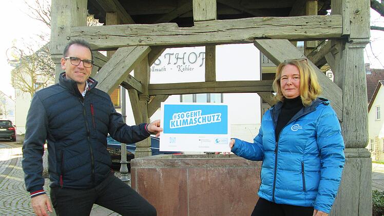 Anlässlich der Umrüstung der Straßenbeleuchtung in Fuchsstadt weisen Bürgermeister René Gerner (l.) und Christine Pfaff(r.) vom Kommunal-Management des Bayernwerks darauf hin, wie Klimaschutz auch "im kleinen" möglich ist.