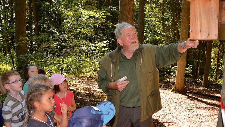 Josef Rüttiger, Jäger Sepp genannt, erklärt den Vorschulkindern, dass ein Kleiber in dem Kasten wohnt. Voller Staunen nehmen die Buben und Mädchen zur Kenntnis, das dieser Vogel das Gehäuse immer verklebt. Foto: Kathrin Kupka-Hahn