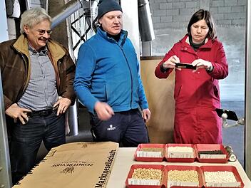 Landwirt Jürgen Herrle (Mitte) zeigt Staatssekretärin Dr. Manuela Rottmann und Richard Mergner, Landesvorsitzender Bund Naturschutz, eine Auswahl des auf dem Zehntfreyhof Neder produzierten Saatguts.