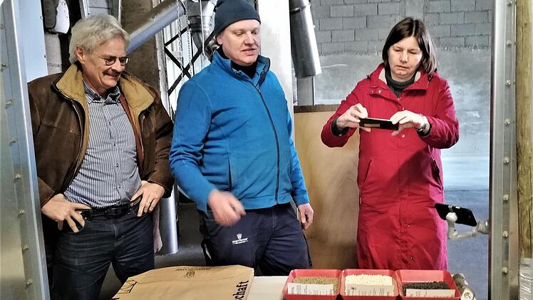 Landwirt Jürgen Herrle (Mitte) zeigt Staatssekretärin Dr. Manuela Rottmann und Richard Mergner, Landesvorsitzender Bund Naturschutz, eine Auswahl des auf dem Zehntfreyhof Neder produzierten Saatguts.