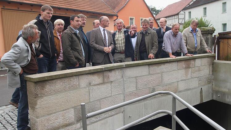 Der Kreisausschuss für Bau und Verkehr schaute sich mit Landrat Wilhelm Schneider (Siebter von links) das Kreisstraßennetz an. Unser Bild zeigt die kreisräte und Schneider hier im Gespräch mit Anlieger Horst Hornung (Achter von links) auf der Ebelsbachbrücke in Dörflis.
