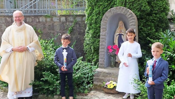 Wegen der Pandemie fand die Erstkommunion in Poppenlauer erst jetzt statt: (von links) Pfarrer Peter Rüb mit den Kommunionkindern Jan Eußner-Dinkel, Lina Niedt und Milo Götz.  Foto: Philipp Bauernschubert