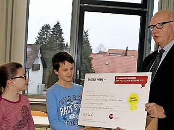 Voller Freude nahmen die Klassensprecher Anna und Pascal den Preis der Bundeszentrale für Politische Bildung entgegen, den ihnen Hans-Georg Lambertz überreichte. Die Klasse 5b der Mittelschule Haßfurt hatte mit ihrer Aktion einen Volltreffer gelandet.  Foto: Sabine Weinbeer
