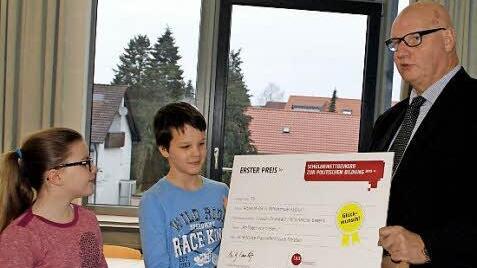 Voller Freude nahmen die Klassensprecher Anna und Pascal den Preis der Bundeszentrale für Politische Bildung entgegen, den ihnen Hans-Georg Lambertz überreichte. Die Klasse 5b der Mittelschule Haßfurt hatte mit ihrer Aktion einen Volltreffer gelandet.  Foto: Sabine Weinbeer