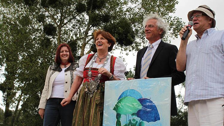 Brigitte Meyerdierks überreicht ein Bild des Bad Brückenauer Brunnens und promt fängt es an zu regnen.