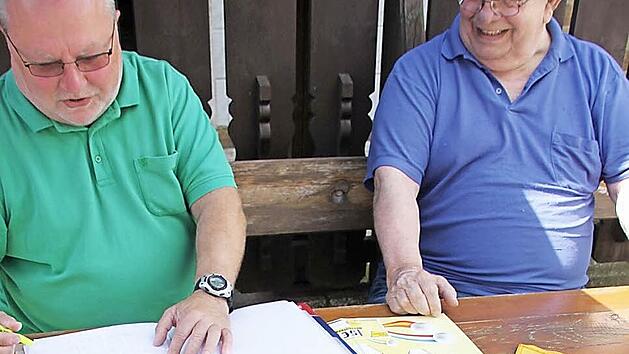 Norbert Zier aus Ebern (links) gibt eben seinen Tipp f&uuml;rs Halbfinale gegen Frankreich ab (womit er falsch lag), wobei einer der Oberaufseher, Robert Quicksall aus Reutersbrunn (rechts), &uuml;ber den ordnungsgem&auml;&szlig;en Eintrag mit dem f&auml;lschungssicheren Originalstift wacht. Foto: Ralf Kestel