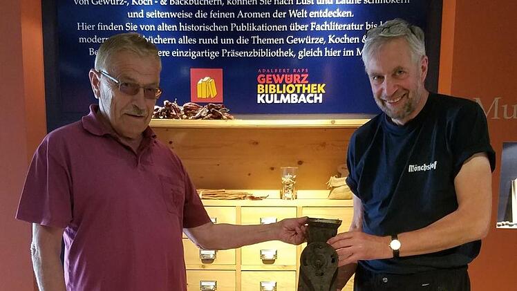 Dieter Dressel (links) übergibt dem Museumsleiter Bernhard Sauermann eine historische Mohnmühle aus dem Familienbesitz.