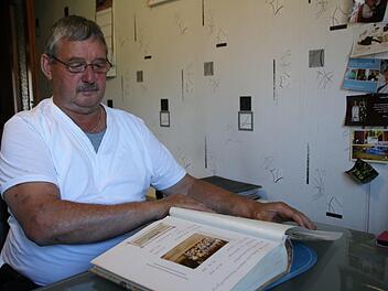 Bruno Herf bl&auml;ttert in einem seiner Fotoalben, in denen die Vereinsgeschichte dokumentiert ist.  Foto: Thomas Malz