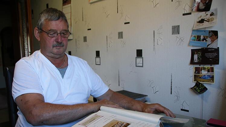 Bruno Herf bl&auml;ttert in einem seiner Fotoalben, in denen die Vereinsgeschichte dokumentiert ist.  Foto: Thomas Malz