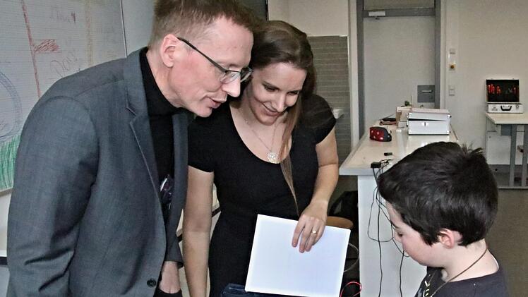 Max Jones erläutert Schulleiter Hartmut Weis und Lehrerin Anja Kilian die Technik, die sein "Lagerfeuer" zum Blinken brachte.
