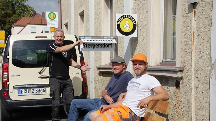 Die Lonnerstadter Gerrit Hoppe, Friedhelm Burgheim und Jens Loeser (von links) vom gemeindlichen Bauhof installierten gestern die erste Mitfahrbank in der Höchstadter Bahnhofstraße. Wer mitgenommen werden möchte, muss nur den Zielort aufklappen und warten.  Foto: Andreas Dorsch