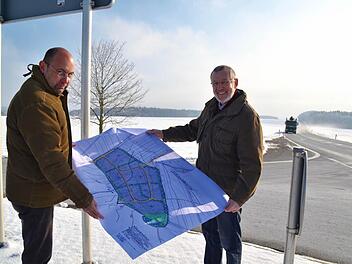 Bürgermeister Waldemar Bug (rechts) und Planer Johannes Hahn stehen hier an der Abfahrt von der Bundesstraße 286 zur Kreisstraße 15 und halten einen ersten Plan für das neue Gewerbegebiet in ihren Händen. Das soll auf der Fläche links der Bundesstraße Richtung Poppenroth entstehen. Foto: Kathrin Kupka-Hahn