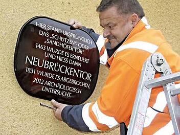 Bauhofmitarbeiter Rainer Müller nimmt Maß, um die Hinweistafel in der Neubrückentorstraße anzubringen.  Foto: Helmut Will