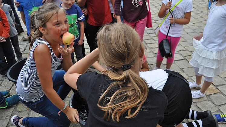 Kaum waren die Köpfe im Wasser hatten die ersten zwei Mädels (links und mit dem Rücken zum Betrachter) schon ihre Äpfel gefangen und ließen sich das Obst schmecken.  Fotos: Ingrid Kohles